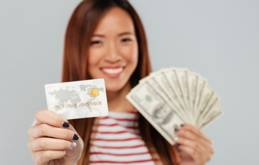 Asian lady portrait, grey background, holding money fan and credit card.