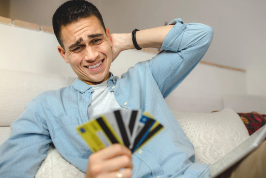young man looking at his credit cards worried