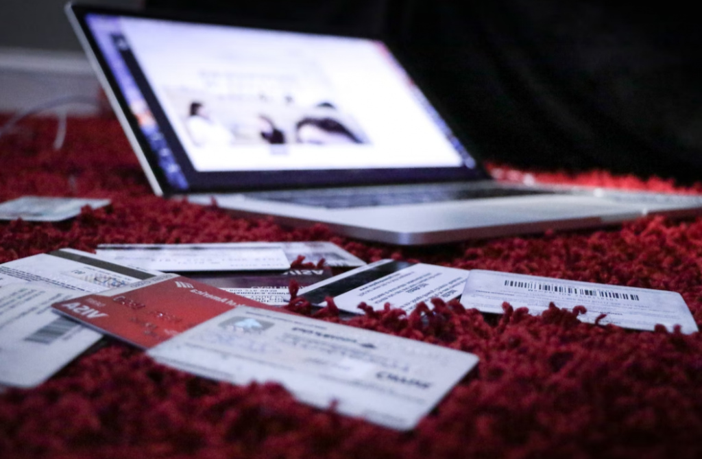 credit cards and laptop on red carpet close up