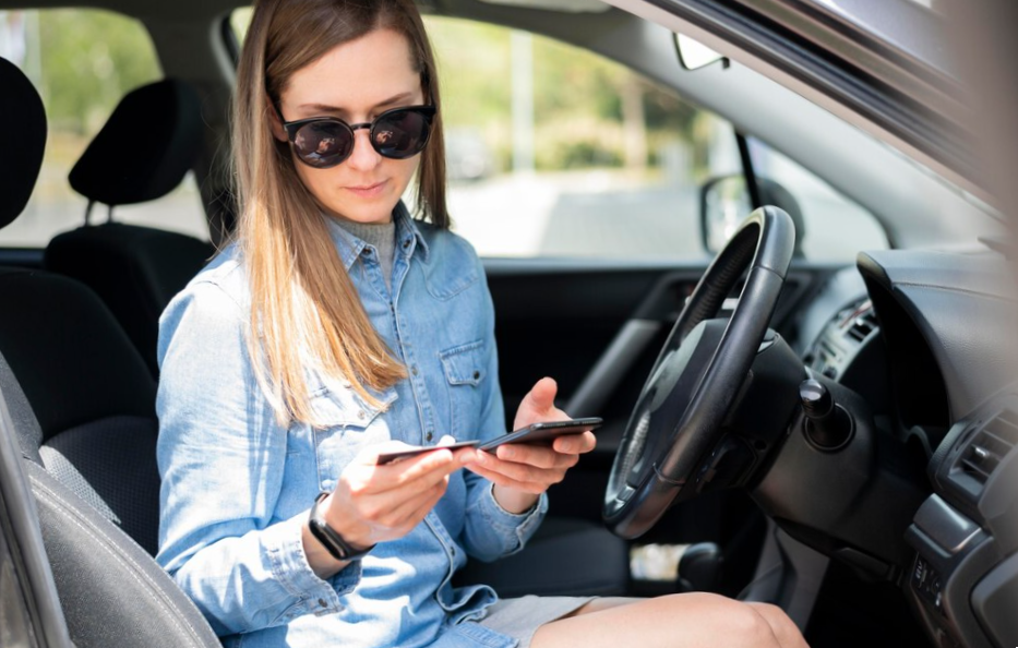 women in her rented car paying with credit card through her phone