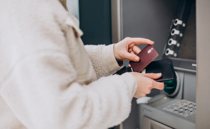 Woman getting her card from the wallet at an atm