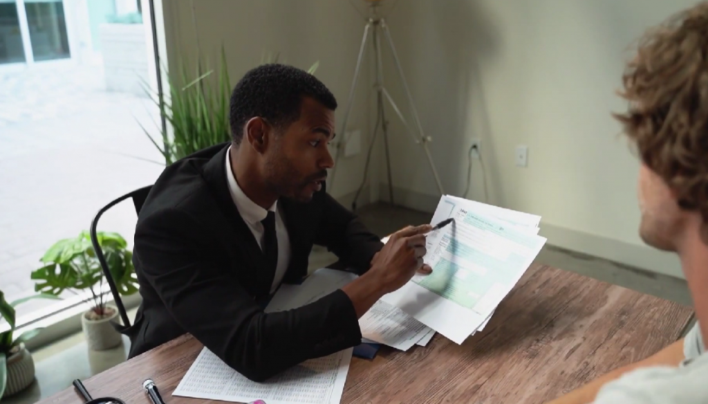 Colored man explaining documents to young man