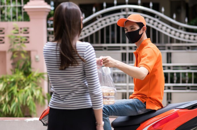 delivery driver giving food to customer