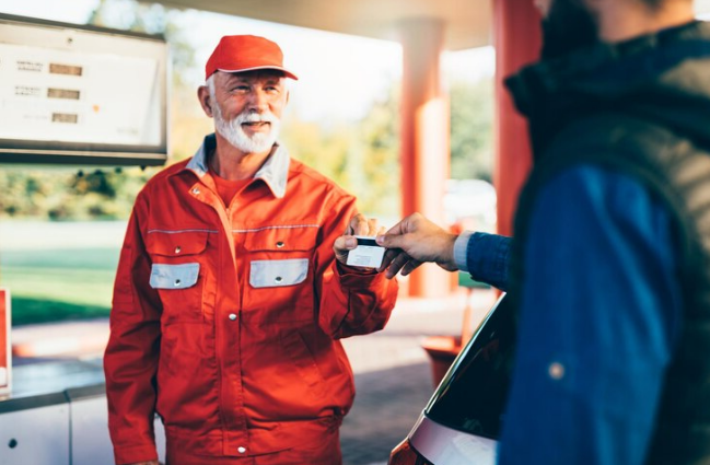 man giving credit card to gas station manager