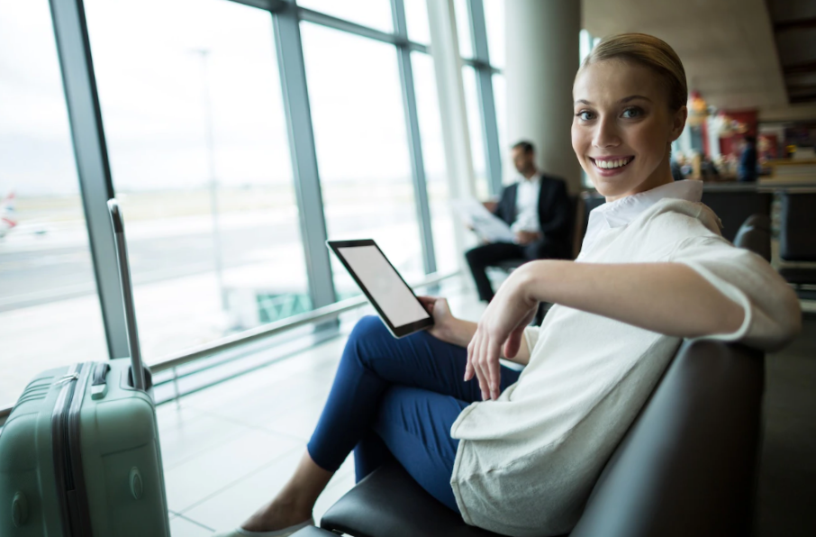 photo portrait of female commuter with digital tablet sitting in waiting area
