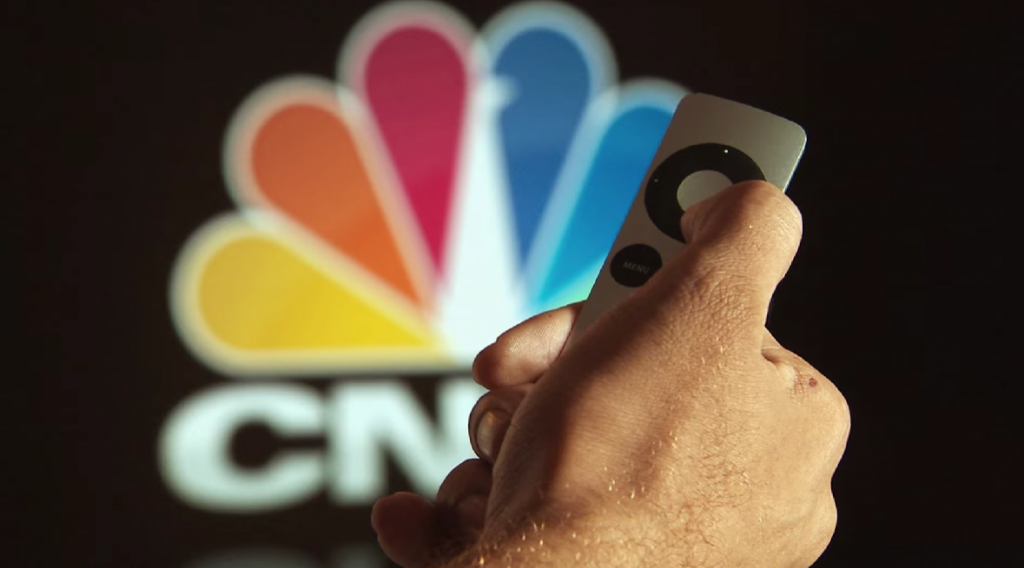 hand with remote control on black background with cnbc logo