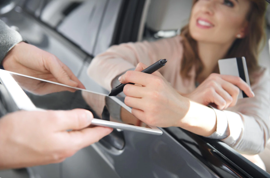 woman in a car signing on a tablet 
