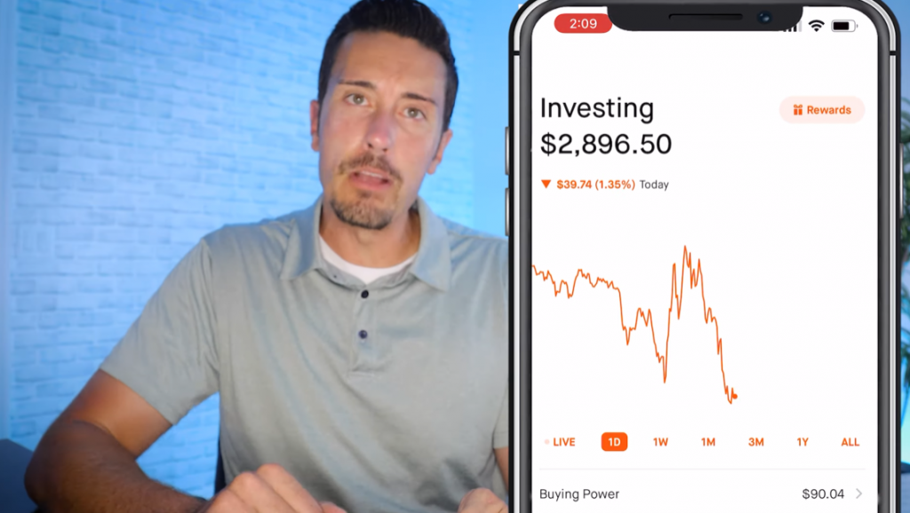 man explaining the stock performance chart showed on a smartphone screen next to him